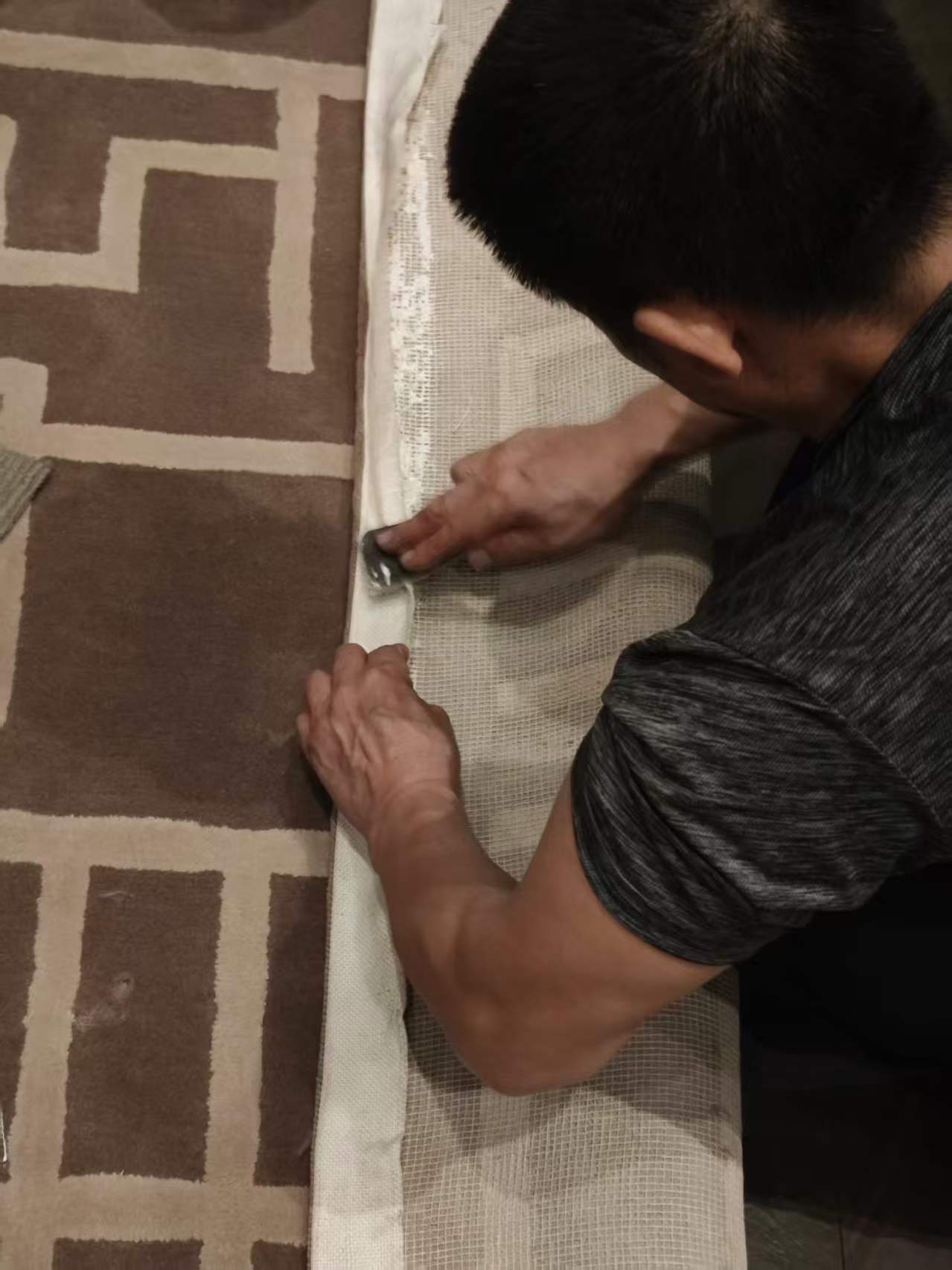 Fitter trimming the edge of the carpet on site